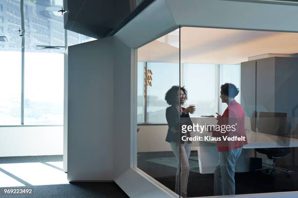businesswomen having discussion in big corner office - luxury girl imagens e fotografias de stock