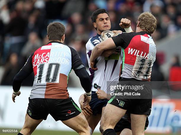Jesse Bromwich of Melbourne Storm gets tackled by Louie McCarthy-Snaresbrook and Luke Williamson of Harlequins RL during a friendly match between...