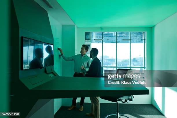 Businessmen having standing meeting inside futuristic meeting room