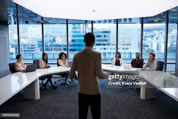 businesspeople having meeting in large futuristic board room - men and women in a large group listening stock-fotos und bilder