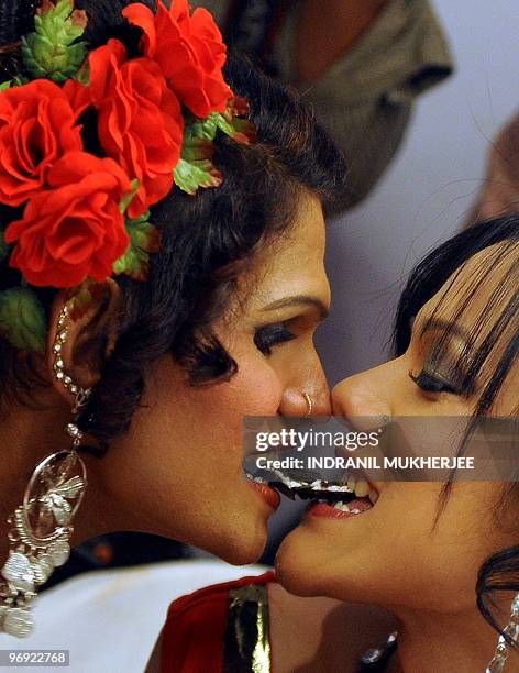 Indian models bite into a biscuit as they pose for a photograph as they prepare for the finals of the 'Indian Super Queen' beauty pagaent for the...