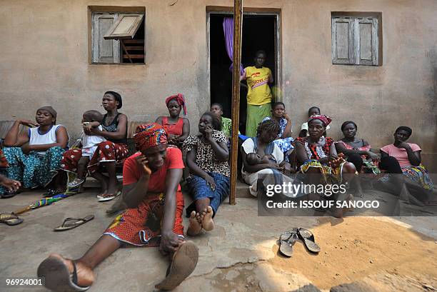 Ivorian women weep after hearing the news that a male relative aged 15 was shots during demonstrations in the western town of Gagnoa on February 20,...