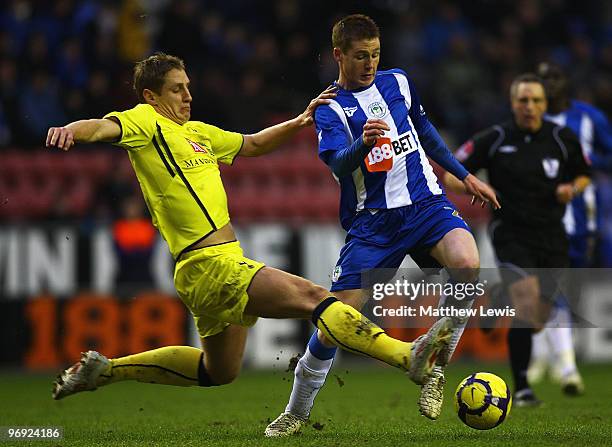 James McCarthy of Wigan is tackled by Michael Dawson of Tottenham during the Barclays Premier League match between Wigan Athletic and Tottenham...