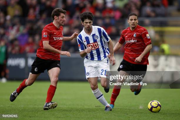 Levan Kobiashvili of Berlin is defended by Hamed Namouchi and Stefan Reisinger of Freiburg during the Bundesliga match between SC Freiburg and Hertha...