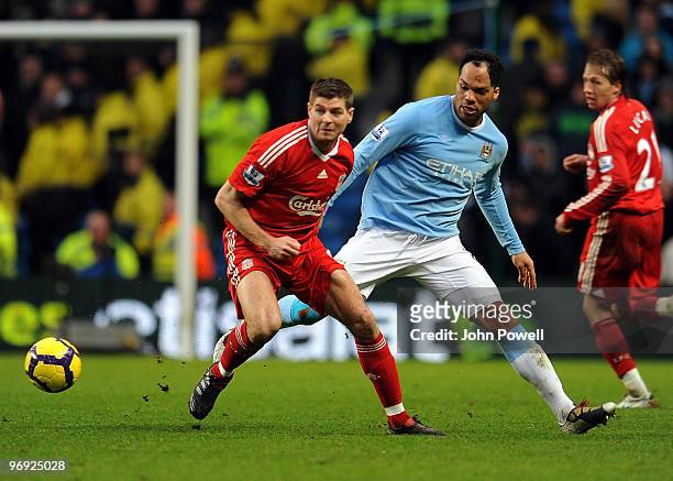 Steven Gerrard of Liverpool competes with Joleon Lescott of Manchester City during the Barclays Premier League match between Manchester City and...