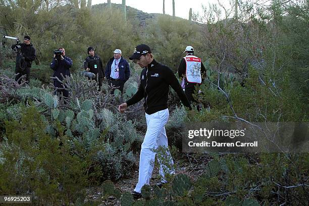 Camilo Villegas of Colombia looks for his golf ball among the Cactii during the continuation of the semi final round of Accenture Match Play...