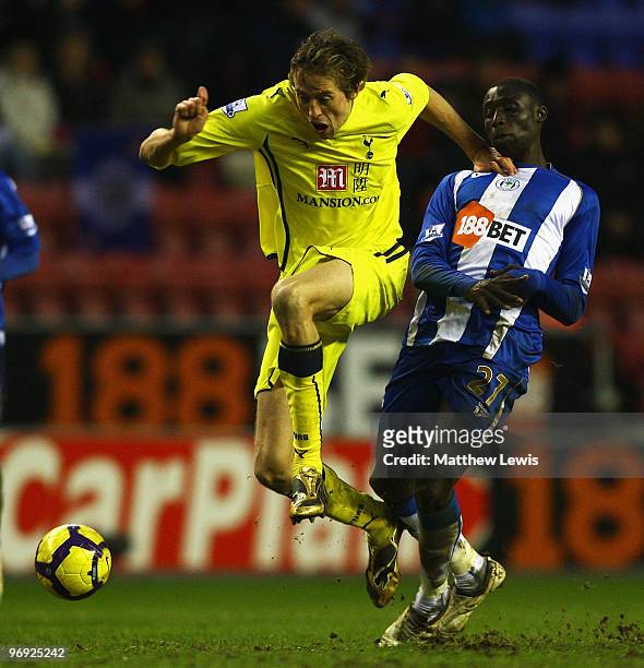 Peter Crouch of Tottenham is tackled by Mohamed Diame of Wigan during the Barclays Premier League match between Wigan Athletic and Tottenham Hotspur...