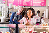 Two multi-ethnic young women in local pastry shop