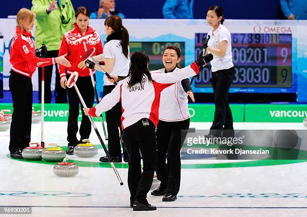 Mari Motohashi of Japan hugs teammate Moe Meguro celebrates after defeating Russia, 12-9, during the women's curling round robin game between Japan...