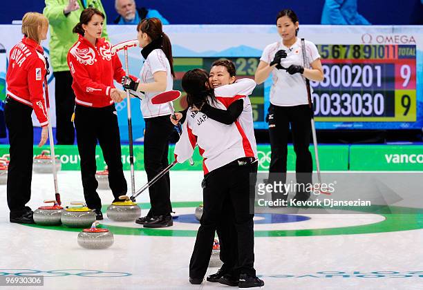 Mari Motohashi of Japan hugs teammate Moe Meguro after defeating Russia, 12-9, during the women's curling round robin game between Japan and Russia...