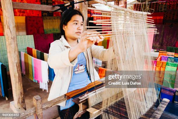 laotian woman working on a spinning loom - laotian culture stock pictures, royalty-free photos & images