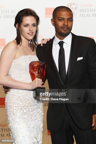 Noel Clarke poses with Kristen Stewart after presentng her with the Orange rising star award in front of the winners boards at the Orange British...