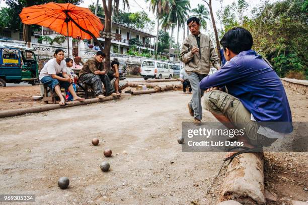 playing petanque in luang prabang - laotian culture stock-fotos und bilder