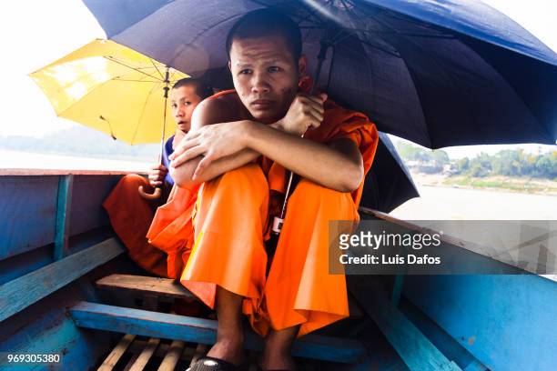 buddhist monks on a rowboat - laotiaanse cultuur stockfoto's en -beelden