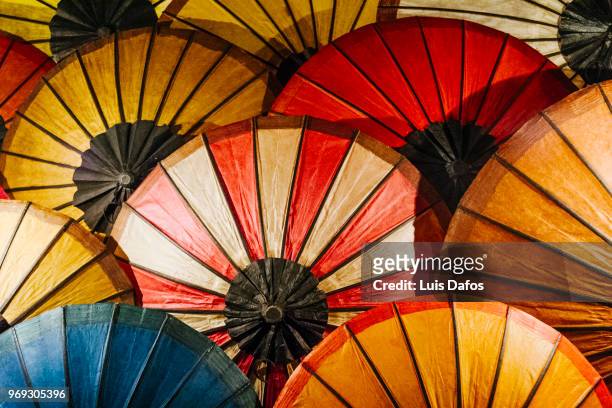paper umbrellas at luang prabang night market - laotiaanse cultuur stockfoto's en -beelden