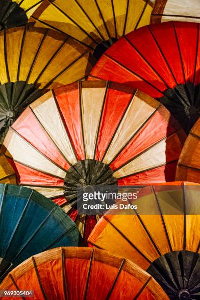 paper umbrellas at luang prabang night market - laotische kultur stock-fotos und bilder