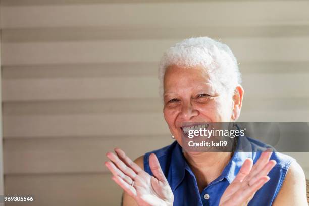 senior hispanic vrouw op de veranda zitten, lachen - clapping hands close up stockfoto's en -beelden