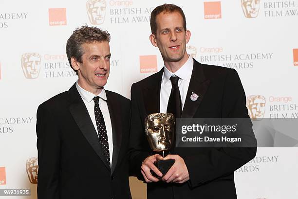 Peter Capaldi poses with Pete Docter after presenting him with the best animated film award in front of the winners boards at the Orange British...