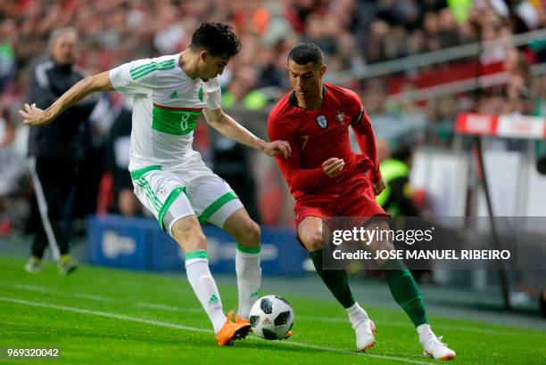 Portuguese forward Cristiano Ronaldo vies with Algerian midfielder Zinedine Ferhat during the friendly football match between Portugal and Algeria,...