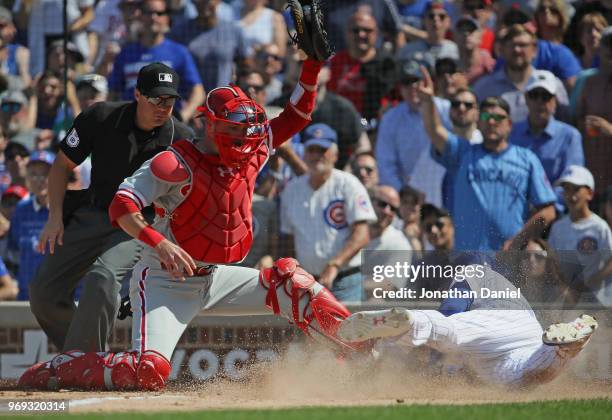 Albert Almora Jr. #5 of the Chicago Cubs dives in score a run as Andrew Knapp of the Philadelphia Phillies is ruled for catcher inference in the 5th...