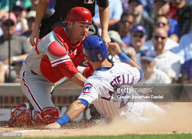 Tommy La Stella of the Chicago Cubs is tagged out at the plate to end the 5th inning by Andrew Knapp of the Philadelphia Phillies at Wrigley Field on...