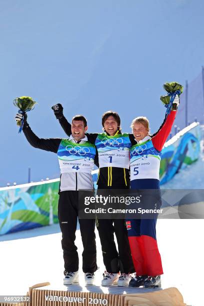 Andreas Matt of Austria celebrates winning silver, Michael Schmid of Switzerland gold and Audun Groenvold of Norway bronze during the flower ceremony...