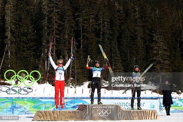 Olga Zaitseva of Russia celebrates winning silver, Magdalena Neuner of Germany gold and Simone Hauswald of Germany bronze during the flower ceremony...