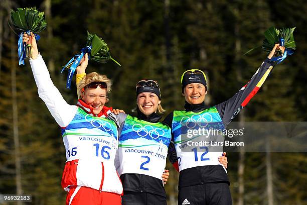 Olga Zaitseva of Russia celebrates winning silver, Magdalena Neuner of Germany gold and Simone Hauswald of Germany bronze during the flower ceremony...