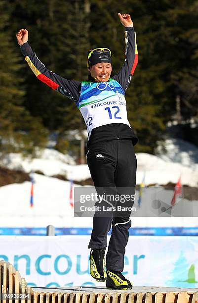 Simone Hauswald of Germany wobbles on the podium as she celebrates bronze during the flower ceremony for the women's 12.5 km mass start biathlon on...