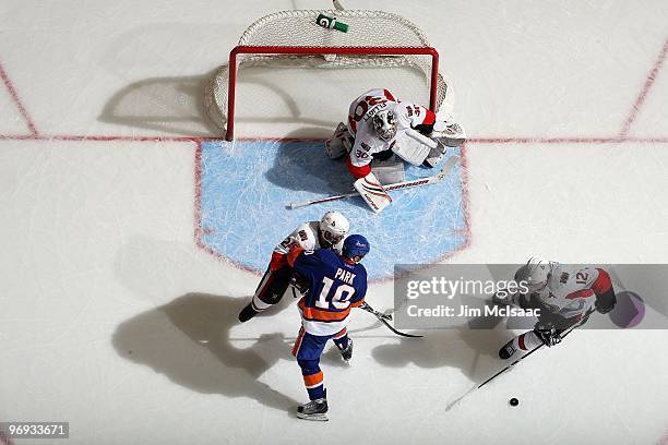 Brian Elliott and Mike Fisher of the Ottawa Senators defend against Richard Park of the New York Islanders on February 14, 2010 at Nassau Coliseum in...