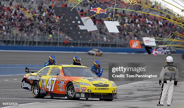 Marcos Ambrose, driver of the Armor All Toyota, is pushed to the garage after engine problems during the NASCAR Sprint Cup Series Auto Club 500 at...