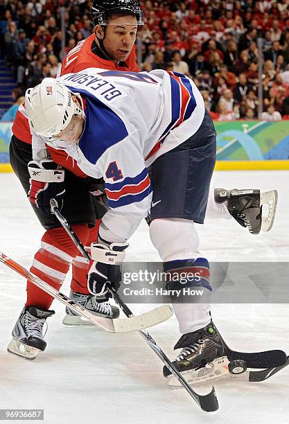 Tim Gleason of the United States attempts to control the puck against Jarome Iginla of Canada during the ice hockey men's preliminary game between...