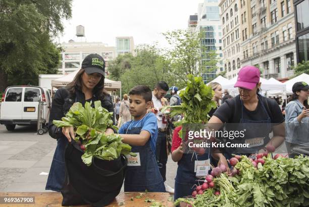 Actresses Andrea Navedo, and Dascha Polanco participate in the "Feeding America's Celebrity Friends Join City Harvest At GrowNYC's Union Square...