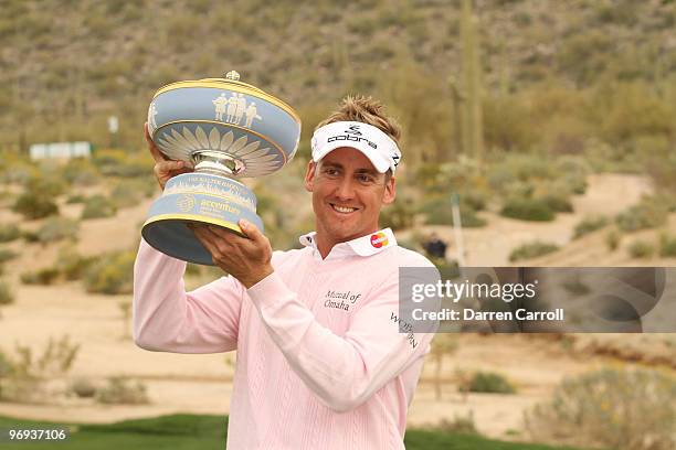 Ian Poulter of England lifts the Walter Hagen Cup trophy on the 16th hole after winning the final round of the Accenture Match Play Championship at...