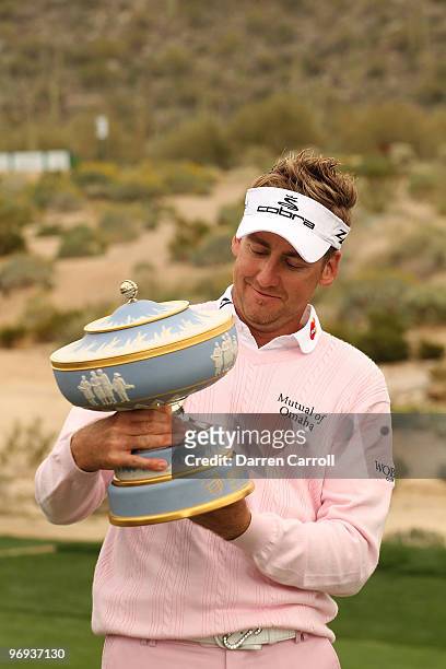 Ian Poulter of England lifts the Walter Hagen Cup trophy on the 16th hole after winning the final round of the Accenture Match Play Championship at...