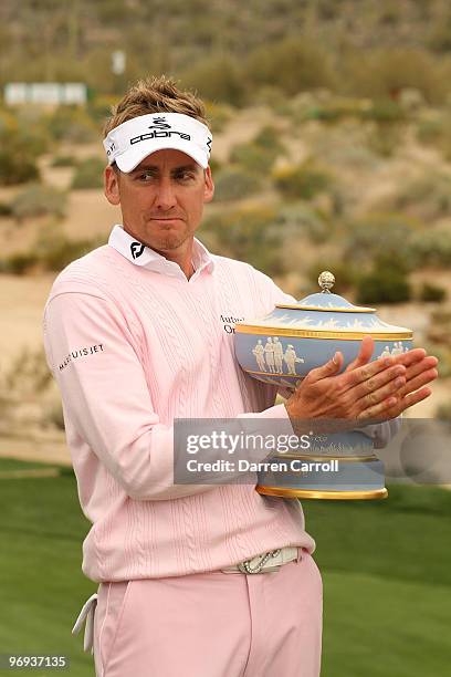 Ian Poulter of England lifts the Walter Hagen Cup trophy on the 16th hole after winning the final round of the Accenture Match Play Championship at...