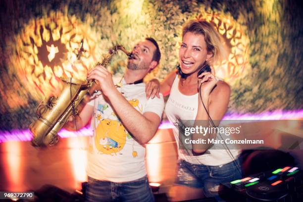 Man is playing saxophone and Giulia Siegel are seen during the opening event for the Peter Pane restaurant on June 7, 2018 in Munich, Germany.