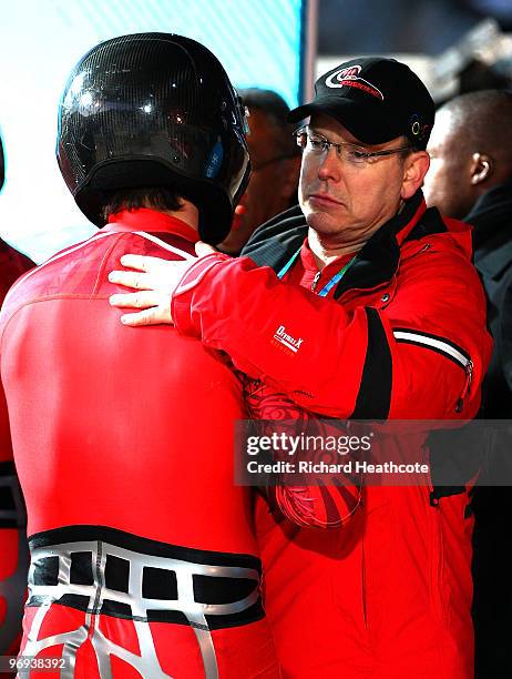 Prince Albert II of Monaco congratulates a member of Monaco 1 during the Two-Man Bobsleigh Heat 4 on day 10 of the 2010 Vancouver Winter Olympics at...