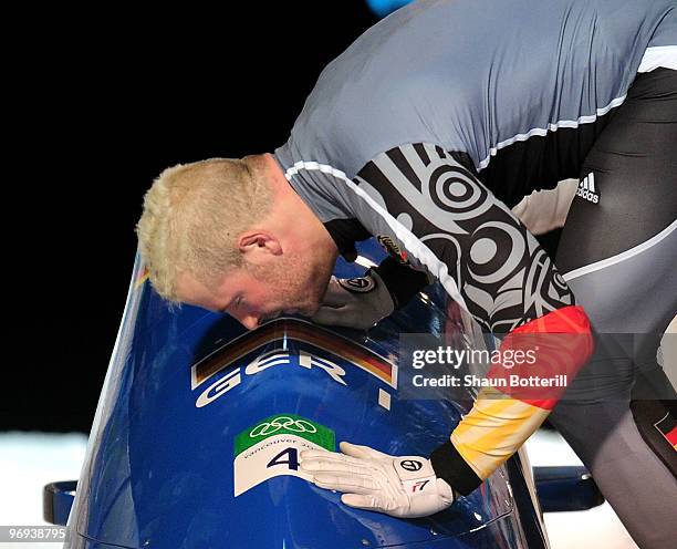 Germany 1's Andre Lange kisses his bobsleigh after winning his fourth gold medal during the Two-Man Bobsleigh Heat 4 on day 10 of the 2010 Vancouver...