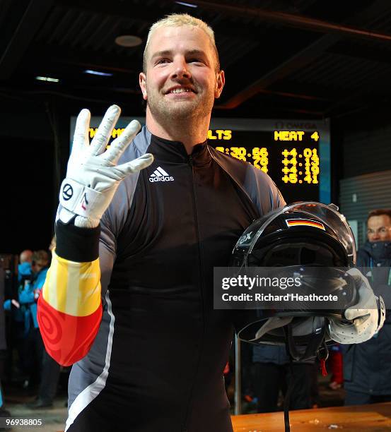 Germany 1's Andre Lange holds up four fingers after winning his fourth gold medal during the Two-Man Bobsleigh Heat 4 on day 10 of the 2010 Vancouver...