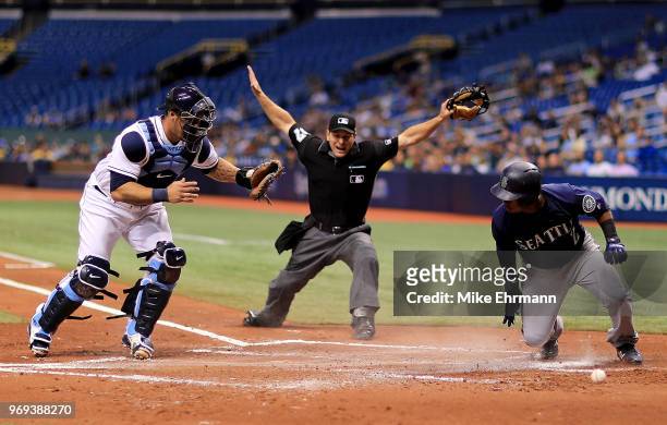 Jean Segura of the Seattle Mariners slides in front of the tag from Wilson Ramos of the Tampa Bay Rays in the second inning during a game at...