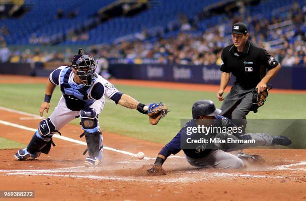 Jean Segura of the Seattle Mariners slides in front of the tag from Wilson Ramos of the Tampa Bay Rays in the second inning during a game at...