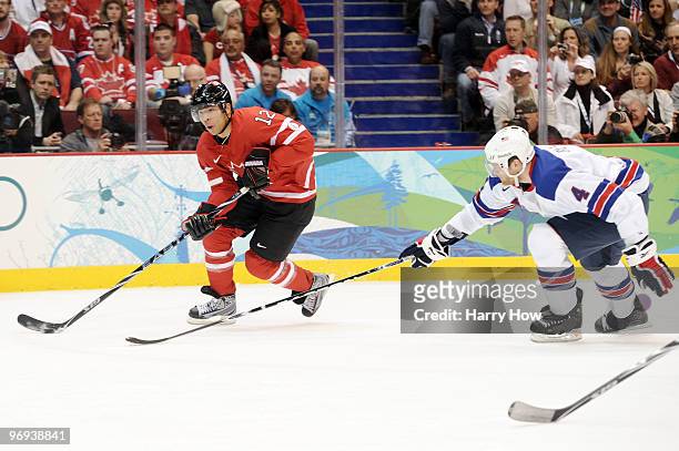 Jarome Iginla of Canada skates with the puck as Tim Gleason of the United States chases him during the ice hockey men's preliminary game between...