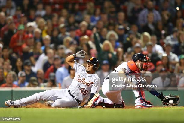 Jeimer Candelario of the Detroit Tigers slides safely into home past the tag of Blake Swihart of the Boston Red Sox in the eighth inning of a game at...