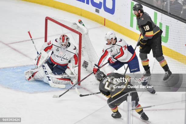 Braden Holtby makes a save while his teammate John Carlson of the Washington Capitals defends against Erik Haula and James Neal of the Vegas Golden...