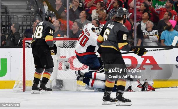 Brett Connolly of the Washington Capitals falls into the knee of his goaltender Braden Holtby after a hit by James Neal of the Vegas Golden Knights...