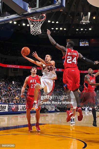 Stephen Curry of the Golden State Warriors scores against Marvin Williams of the Atlanta Hawks on February 21, 2010 at Oracle Arena in Oakland,...