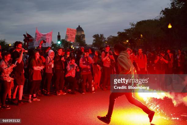 Protester runs with a flare outside the National Assembly of Quebec during a demonstration ahead of the Group of Seven Leaders' Summit in Quebec...
