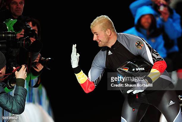 Germany 1's Andre Lange holds up four fingers after winning his fourth gold medal during the Two-Man Bobsleigh Heat 4 on day 10 of the 2010 Vancouver...