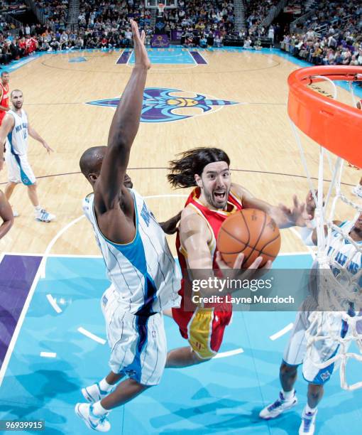 Luis Scola of the Houston Rockets shoots over Emeka Okafor and David West of the New Orleans Hornets on February 21, 2010 at the New Orleans Arena in...